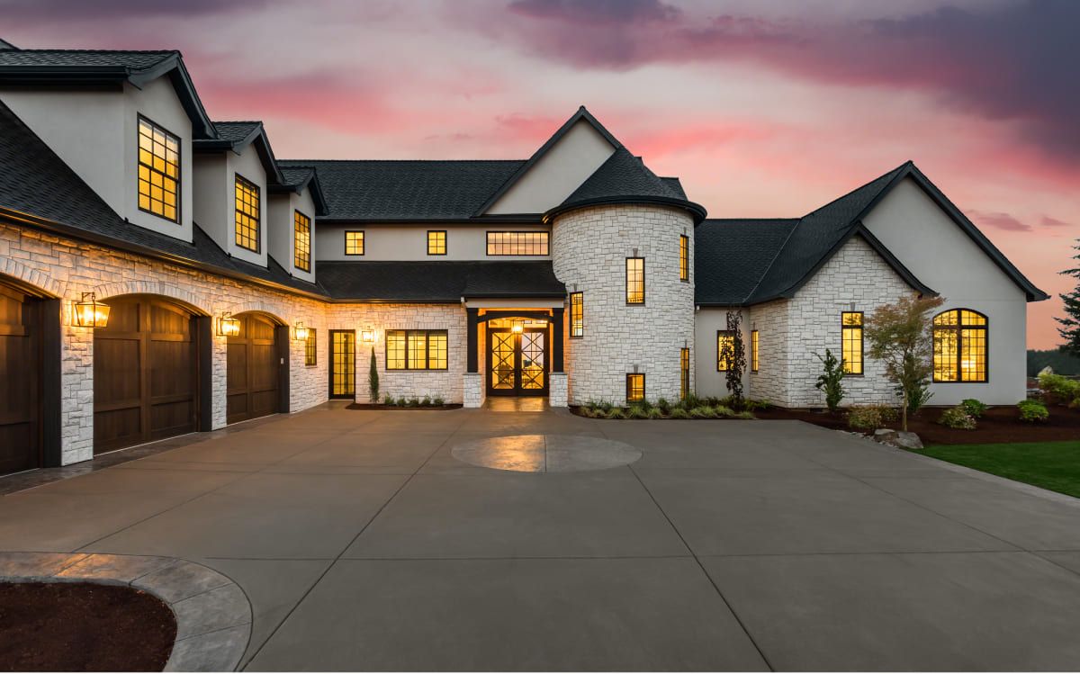 A stone-and-stucco family home lit at dusk.